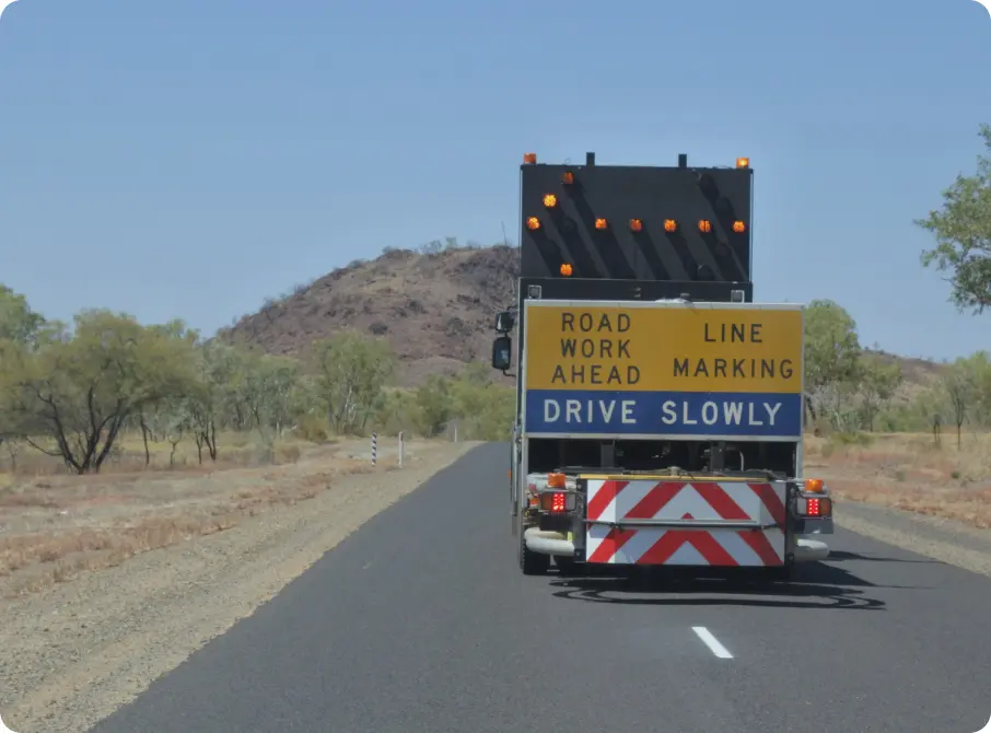 Roadworks truck labelled 'road work ahead, drive slowly'